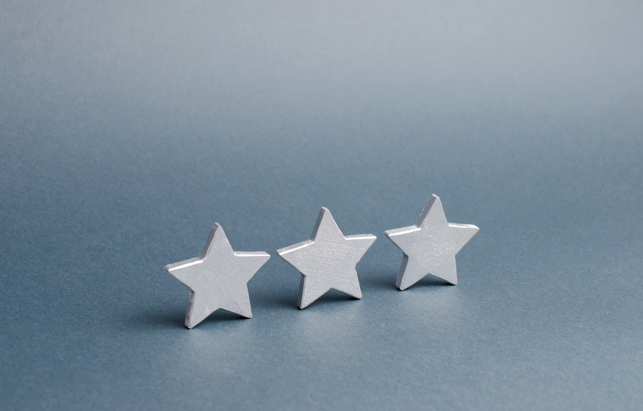 Three stars on a gray background. The concept of rating and evaluation. The rating of the hotel, res