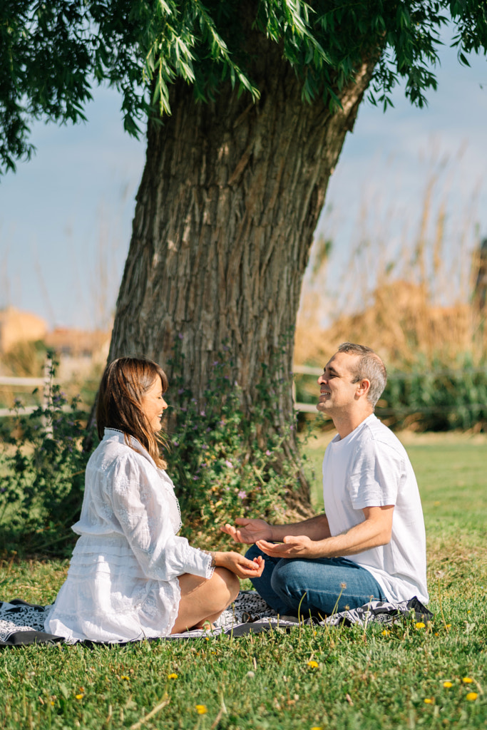 Happy couple sitting on field by Olha Dobosh on 500px.com