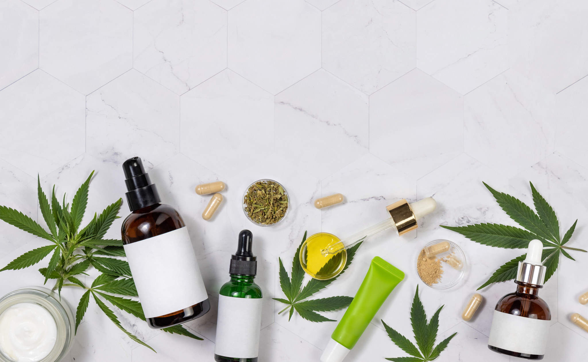 Cosmetics with blank labes, Pipette with CBD oil, hemp capsules and green cannabis leaves