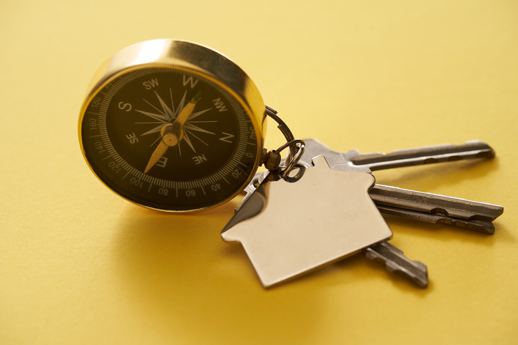 compss guidance and model house keyring on yellow background