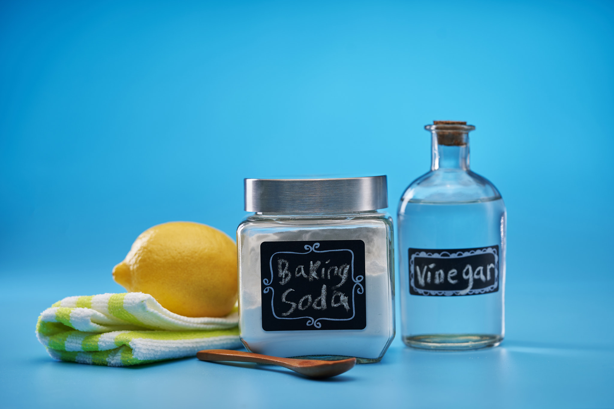 baking soda lemon and vinegar against blue background