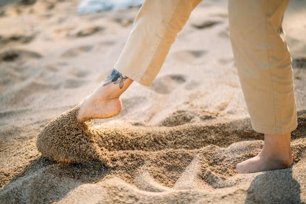 Low section of woman standing on sand at beach by Olha Dobosh on 500px.com