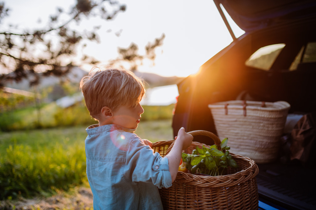 Little boy giving picnic basket in their electric car. by Jozef Polc on 500px.com