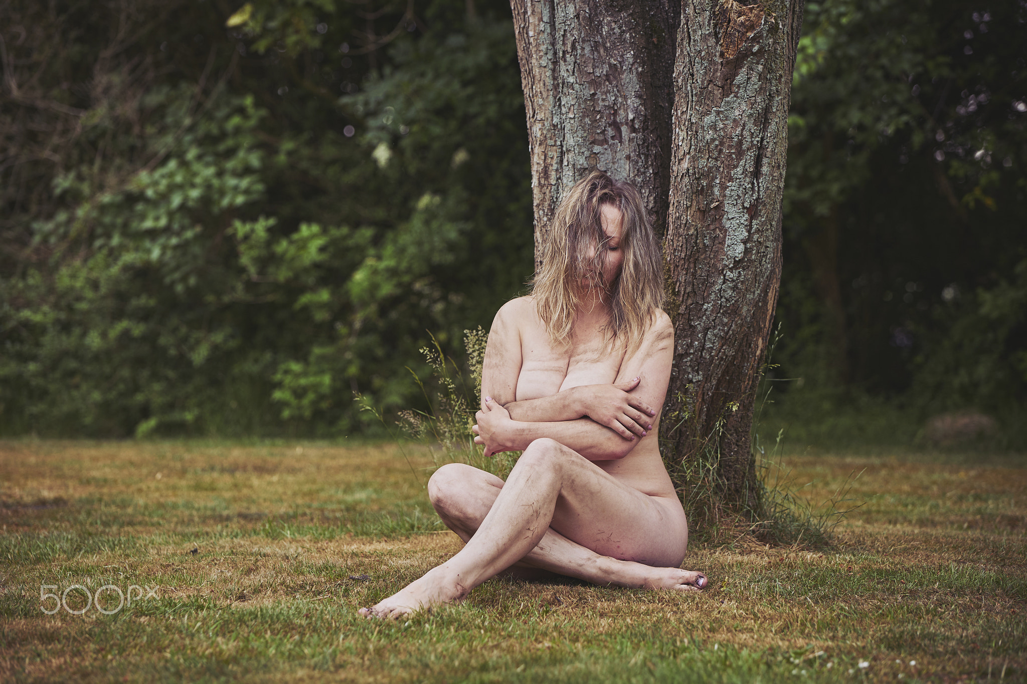 Naked dirty woman in the evening forest