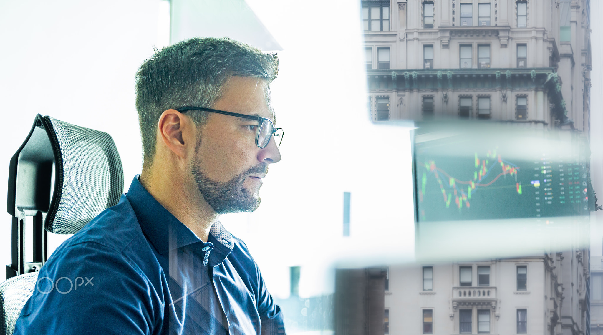 Stock broker trading online watching charts and data analyses on multiple computer screens.