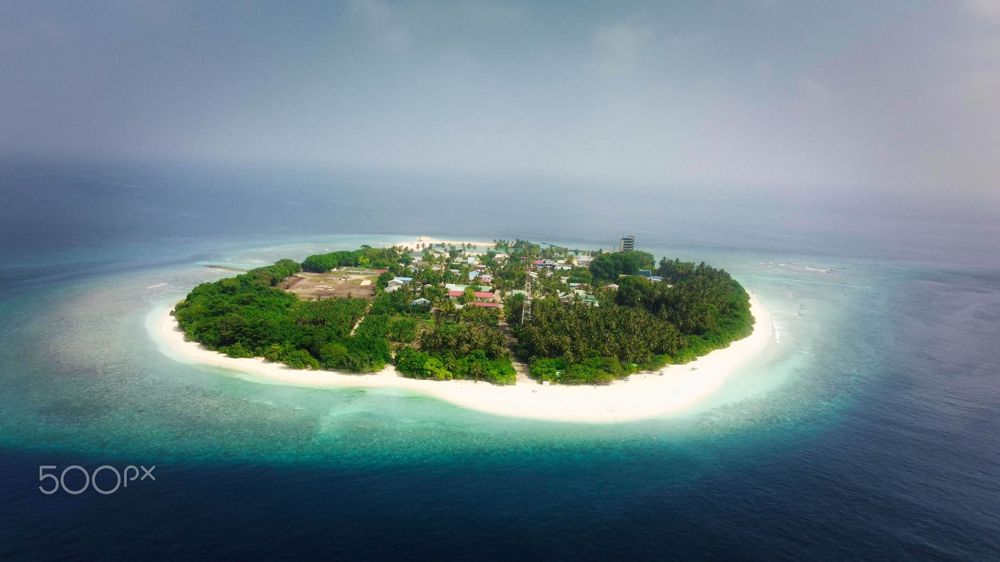 Tropical paradise with blue sea and green island in the maldives