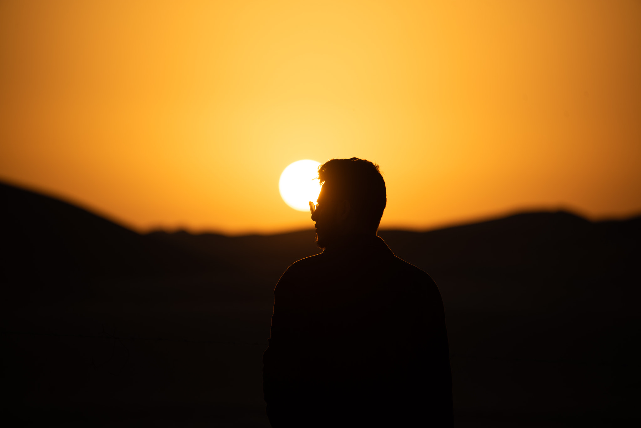 Silhouette man standing against sky during sunset