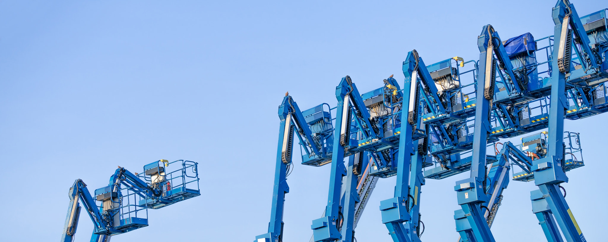 Articulated boom lift. Aerial platform lift. Telescopic boom lift against clear sky. Mobile crane