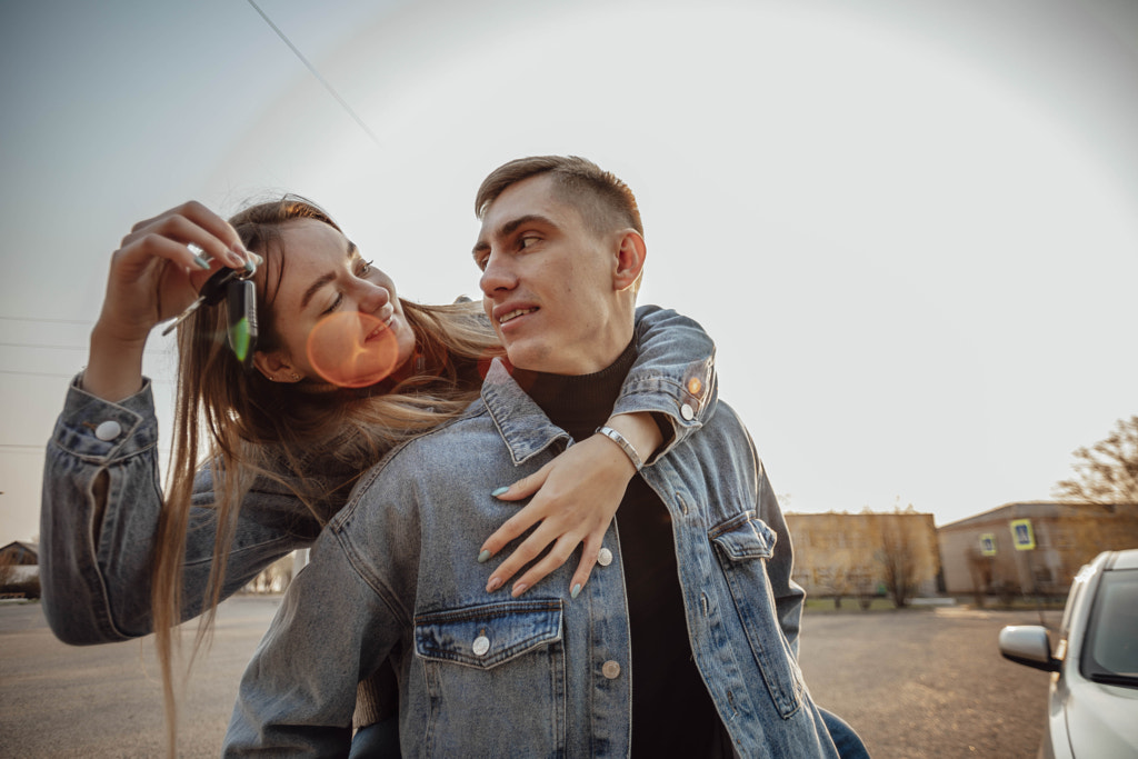 young couple holds car keys for travel: purchase or rental by Aiman Dairabaeva on 500px.com