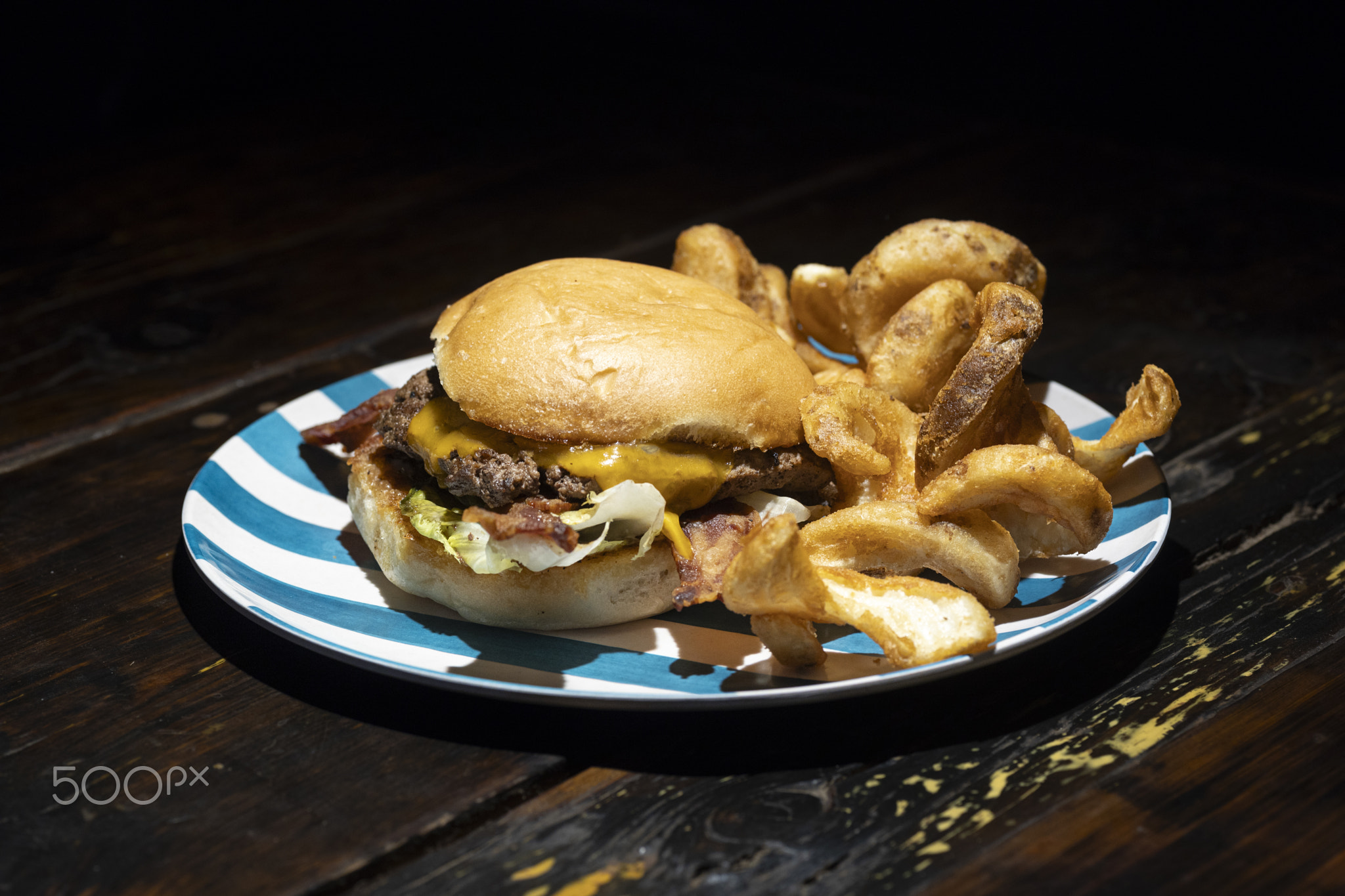 Bacon cheeseburger on brioche bun thick cut fries.