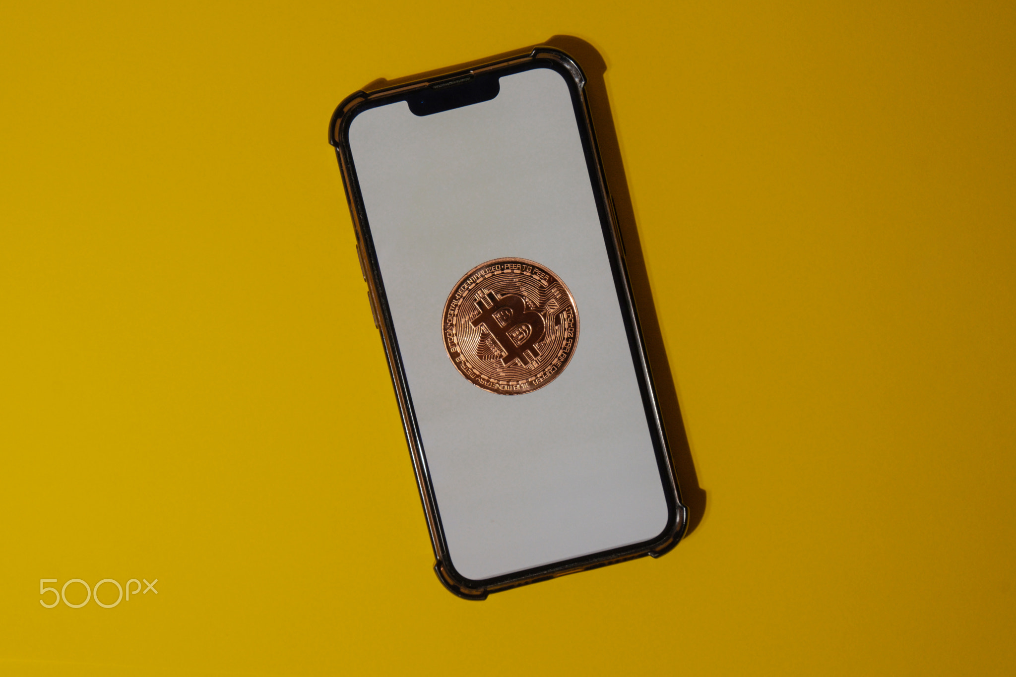 Bitcoin gold coin on mobile phone with white screen. Mining trading