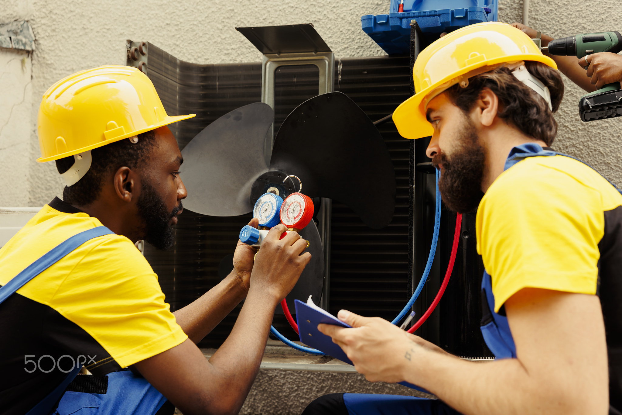 Wiremen refilling freon in HVAC system