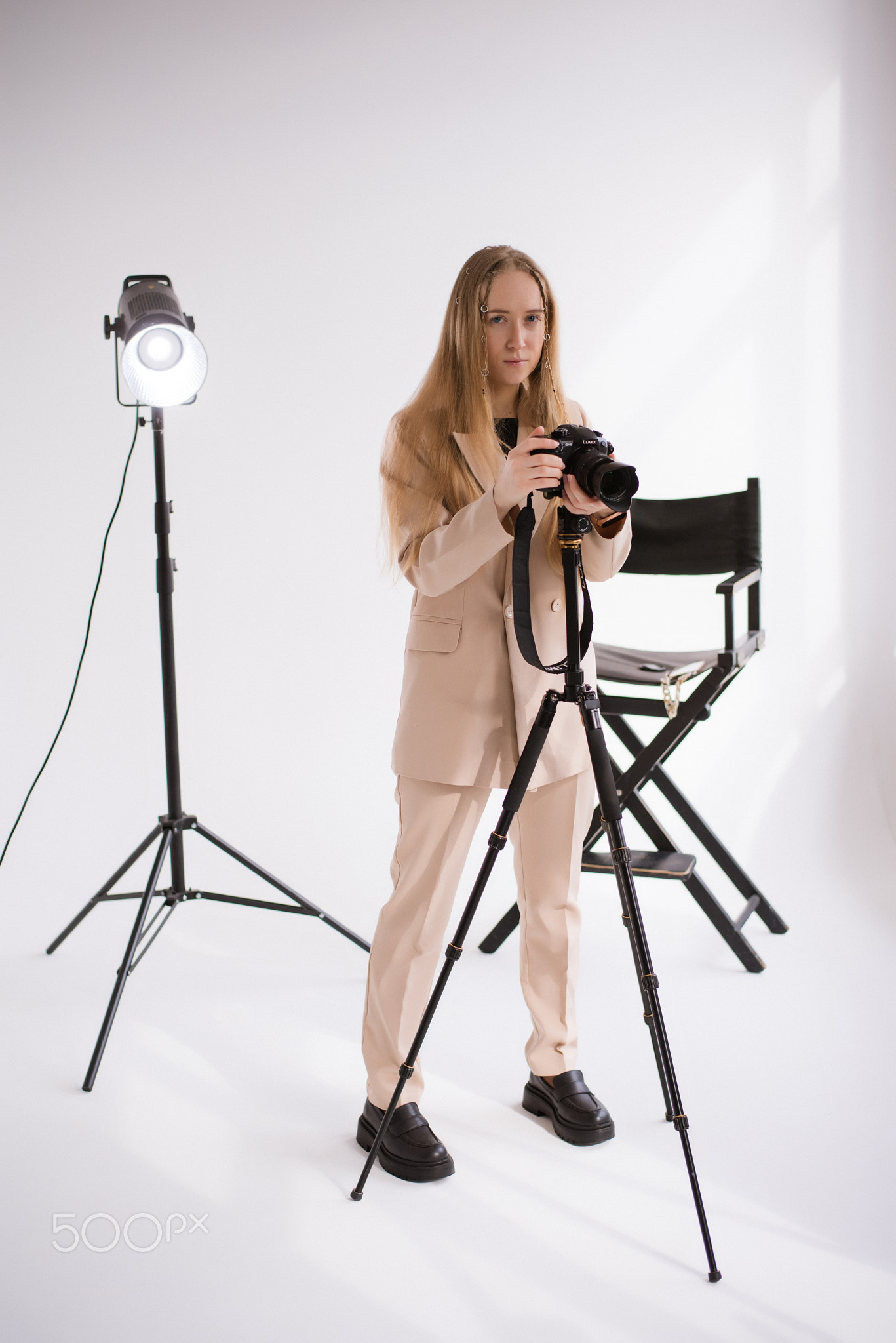 A woman videographer with camera in studio