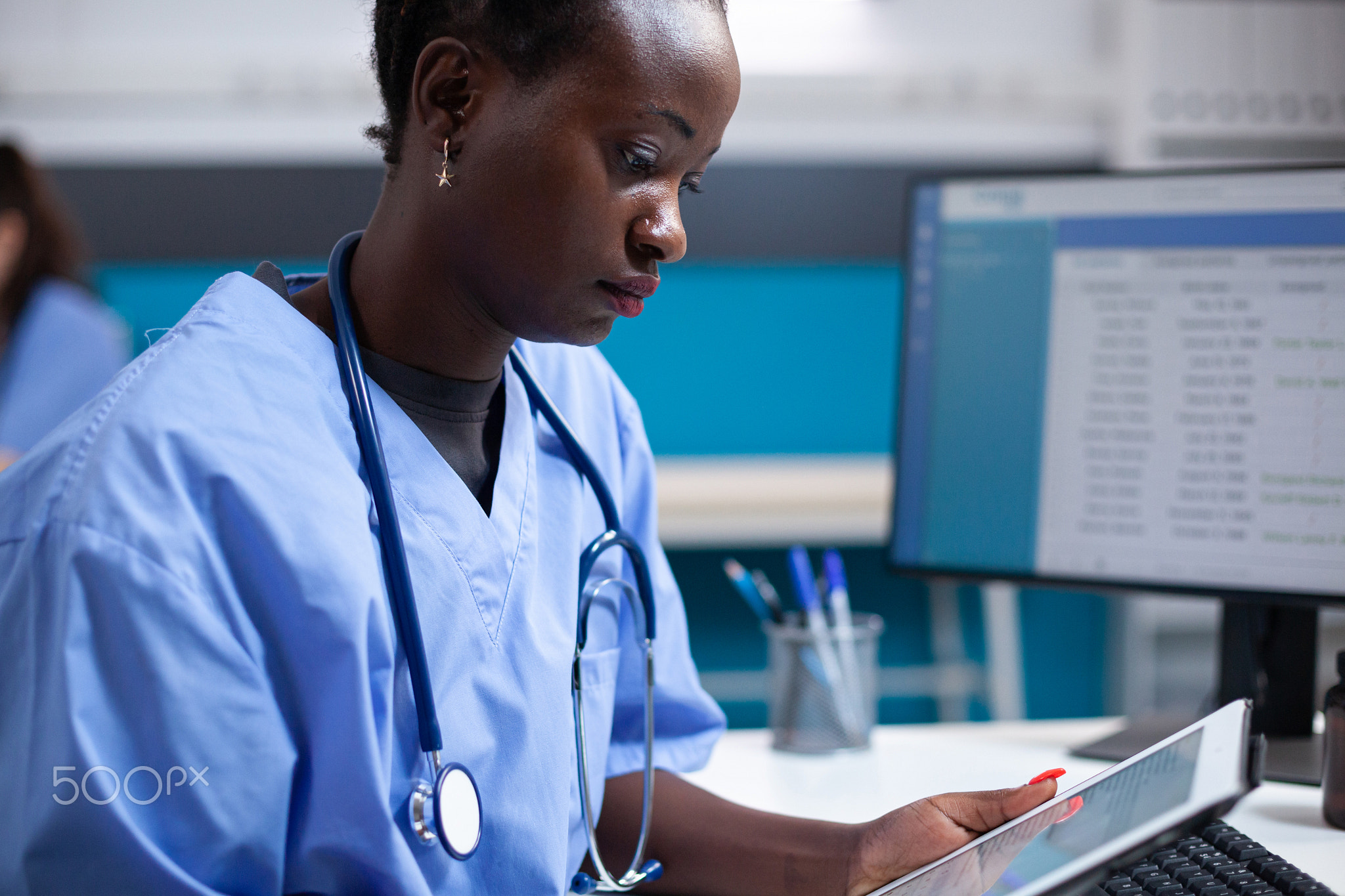 Nurse checking patient data on tablet