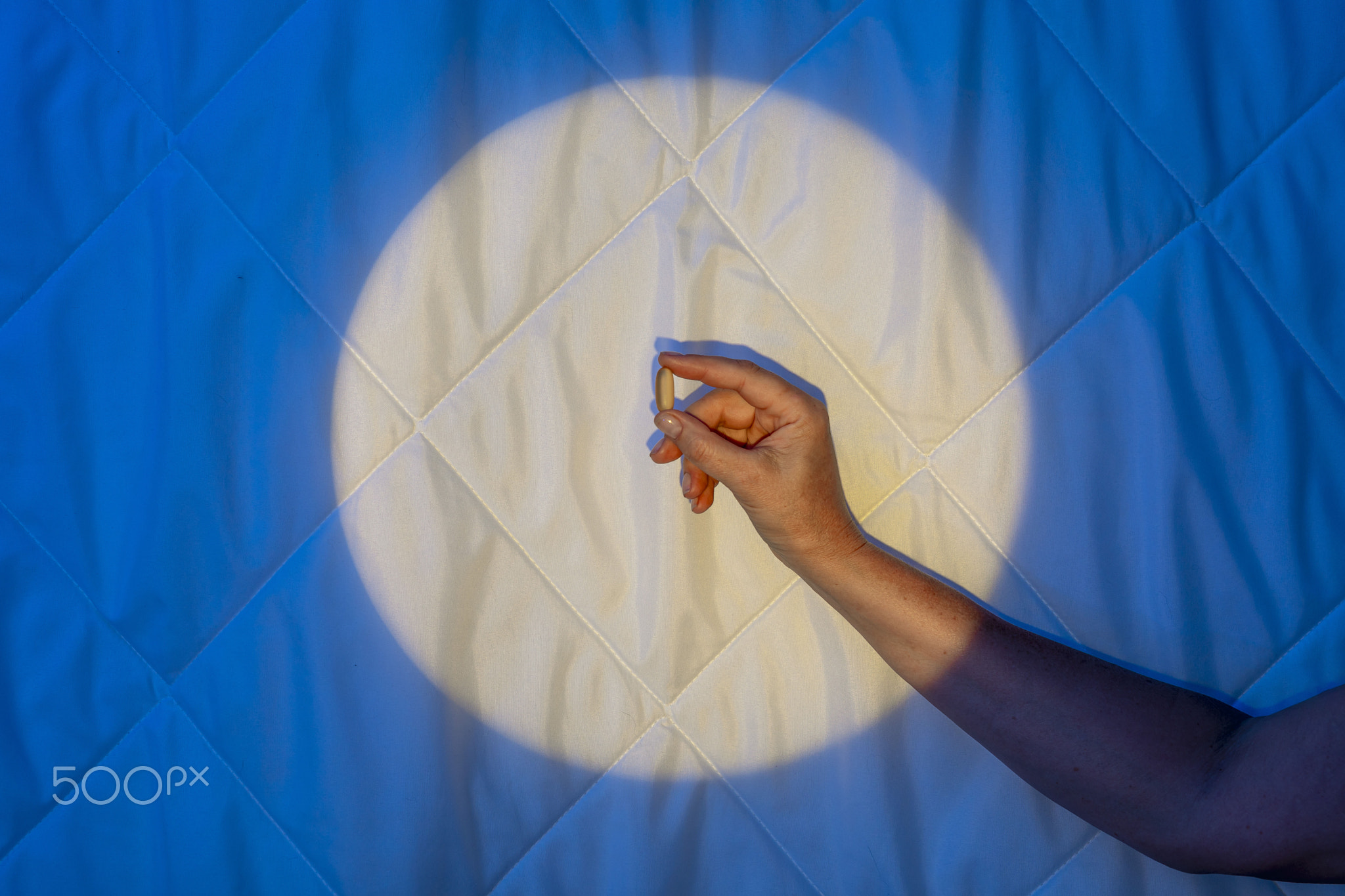 Sleeping capsule, hand in moonlight on a blanket, Melatonin's Fight against Insomnia