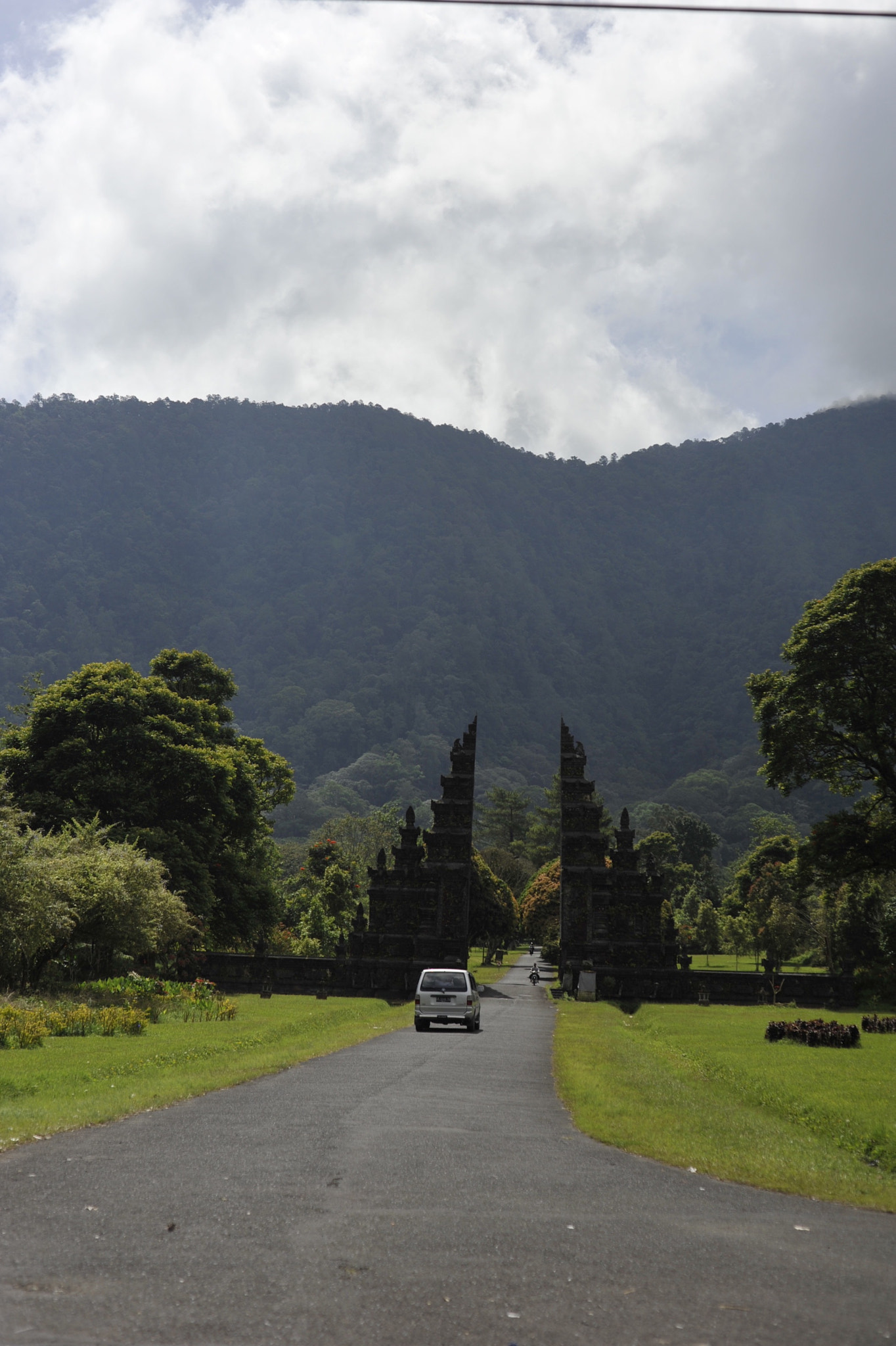 Empty road amidst trees against sky