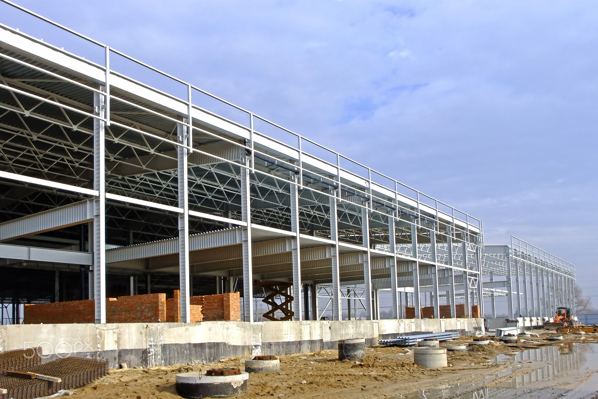 Construction of a large logistics complex made of metal structures. The frame of the building is in