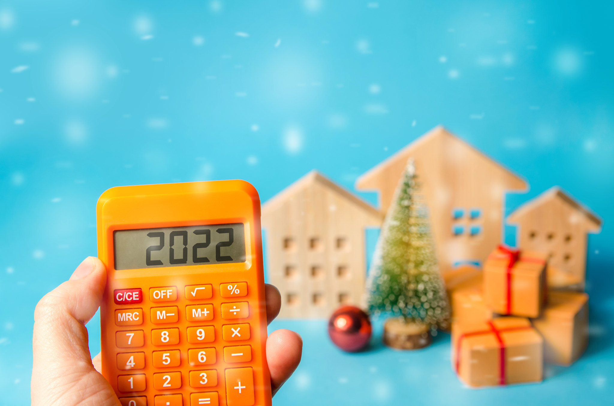 Calculator 2022, Christmas tree and miniature houses. Accumulating money and planning a budget. Busi