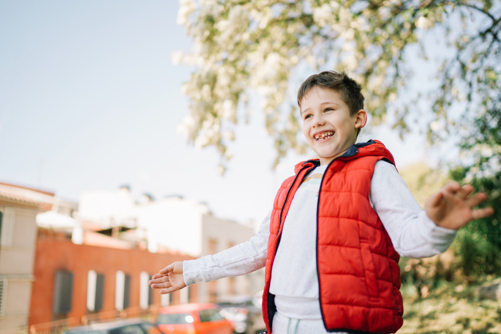 Portrait of smiling boy with arms outstretched standing on footpath against sky by Olha Dobosh on 500px.com