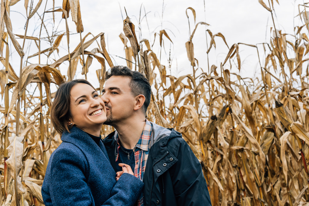 Happy couple in love in autumn in a cornfield. A man kisses a woman on the cheek by Tatsiana Kalasouskaya on 500px.com