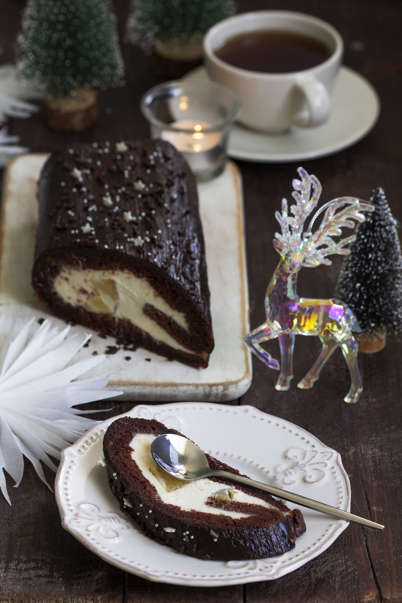 Chocolate roll stuffed with butter cream and pineapple on a Christmas background. Rustic style.