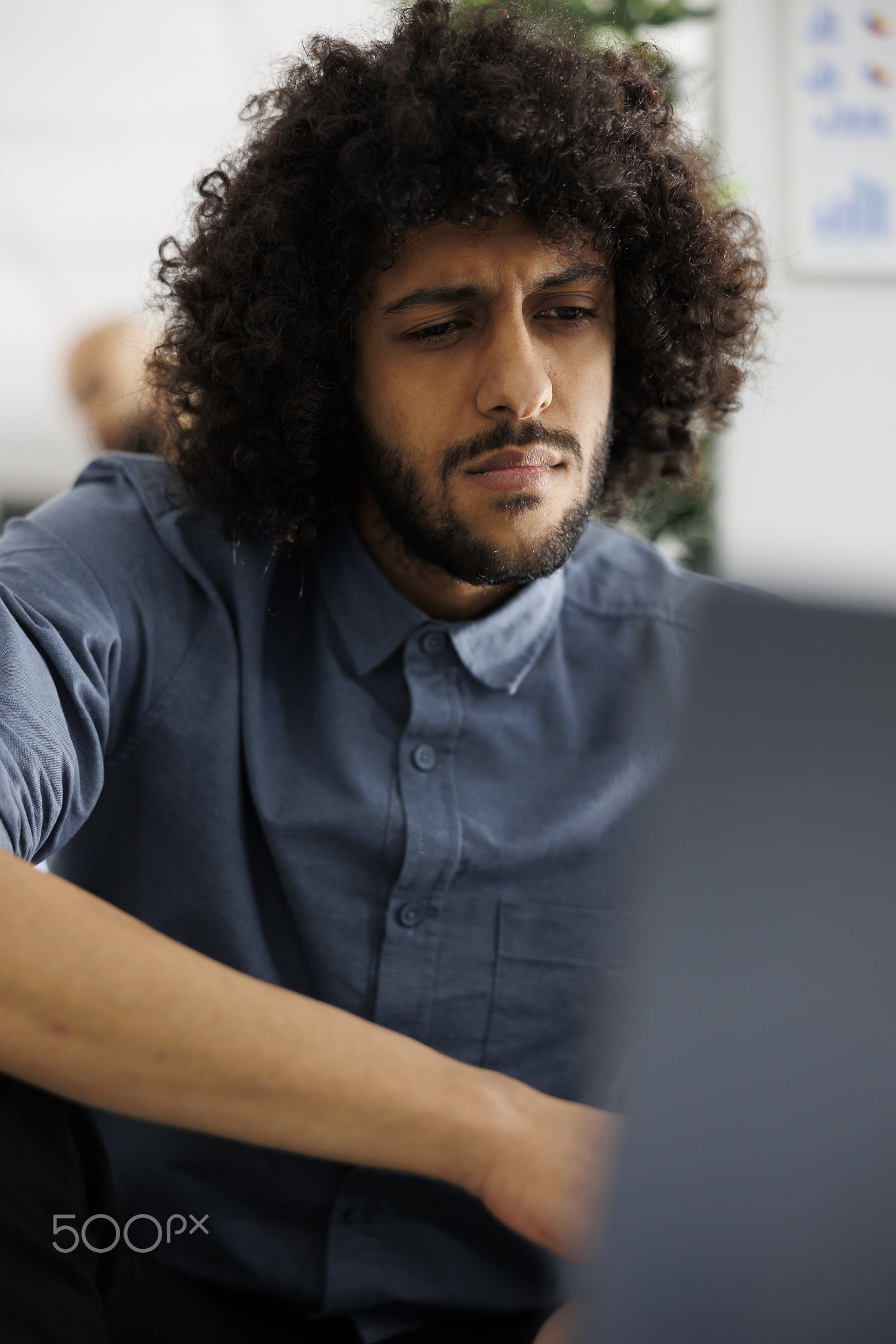 Young arab financial analyst analyzing statistics on laptop