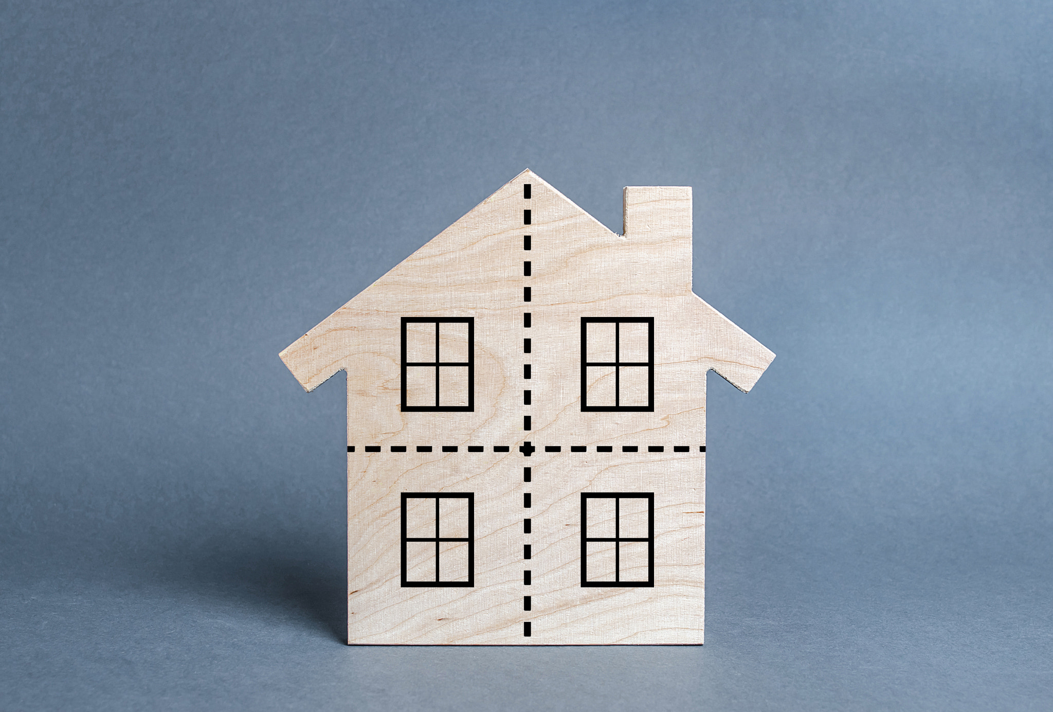 Residential building divided by a dotted line into four equal parts. Divorce concept. Disputes over
