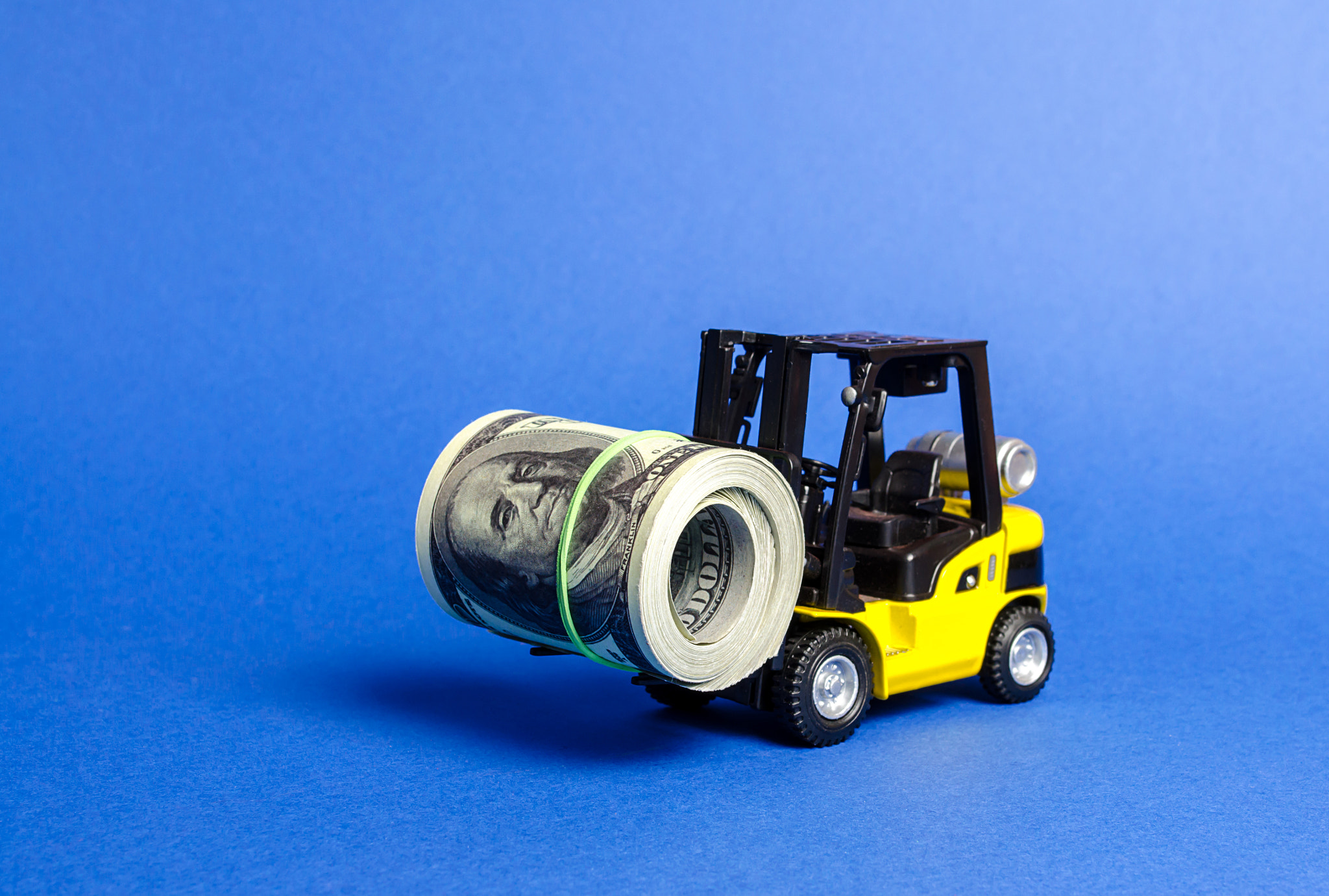 Forklift truck carries a bundle of dollars. Export of capital, offshore economic zones. Attracting d