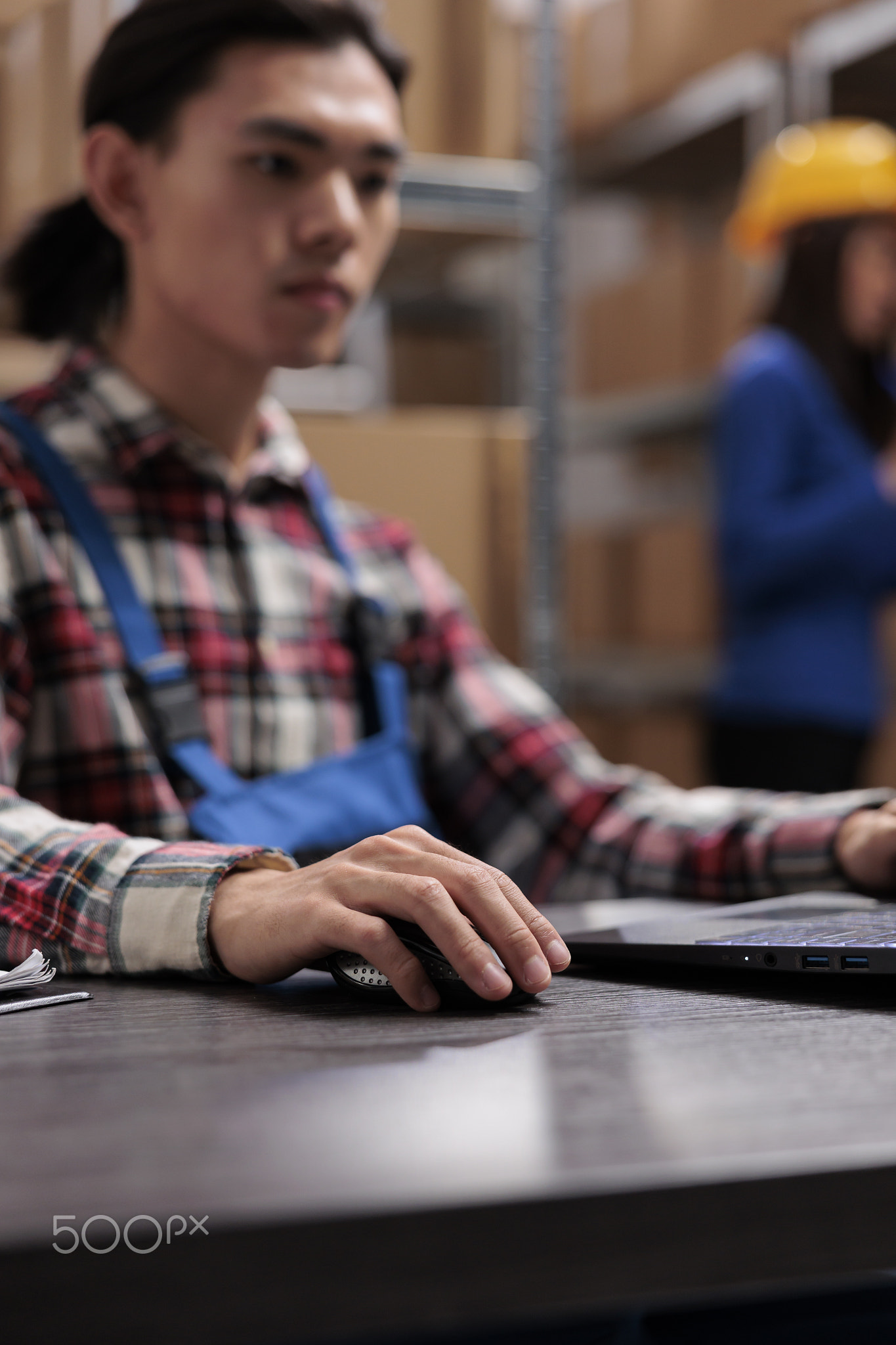 Young asian logistics manager analyzing goods supply on laptop