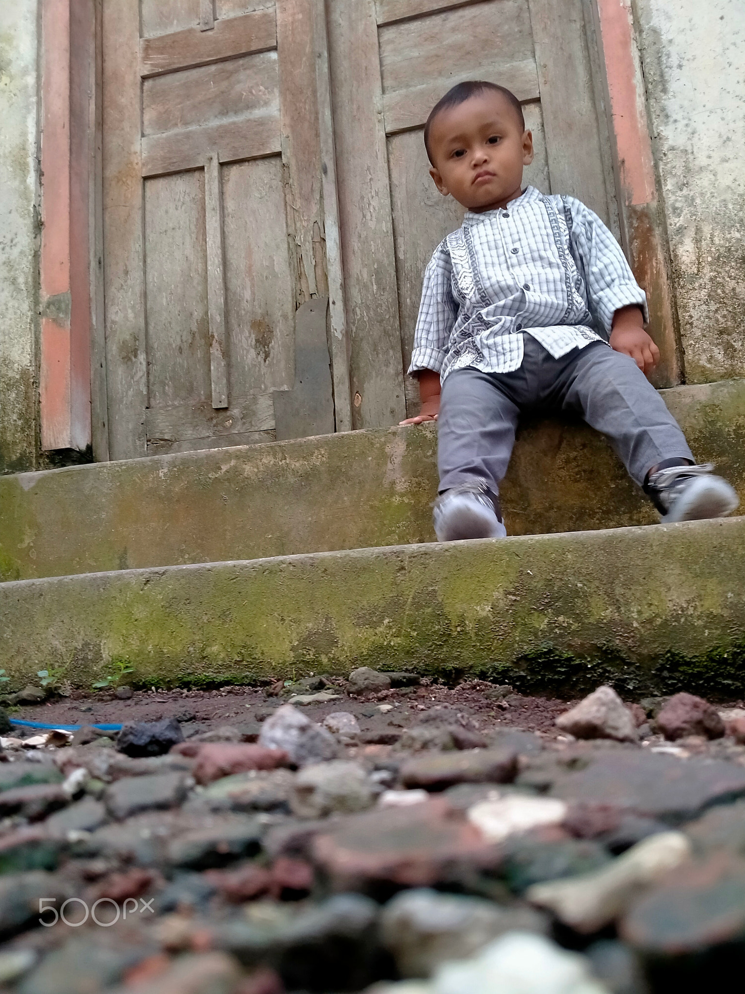a small child tries to pose in front of the camera in a natural style