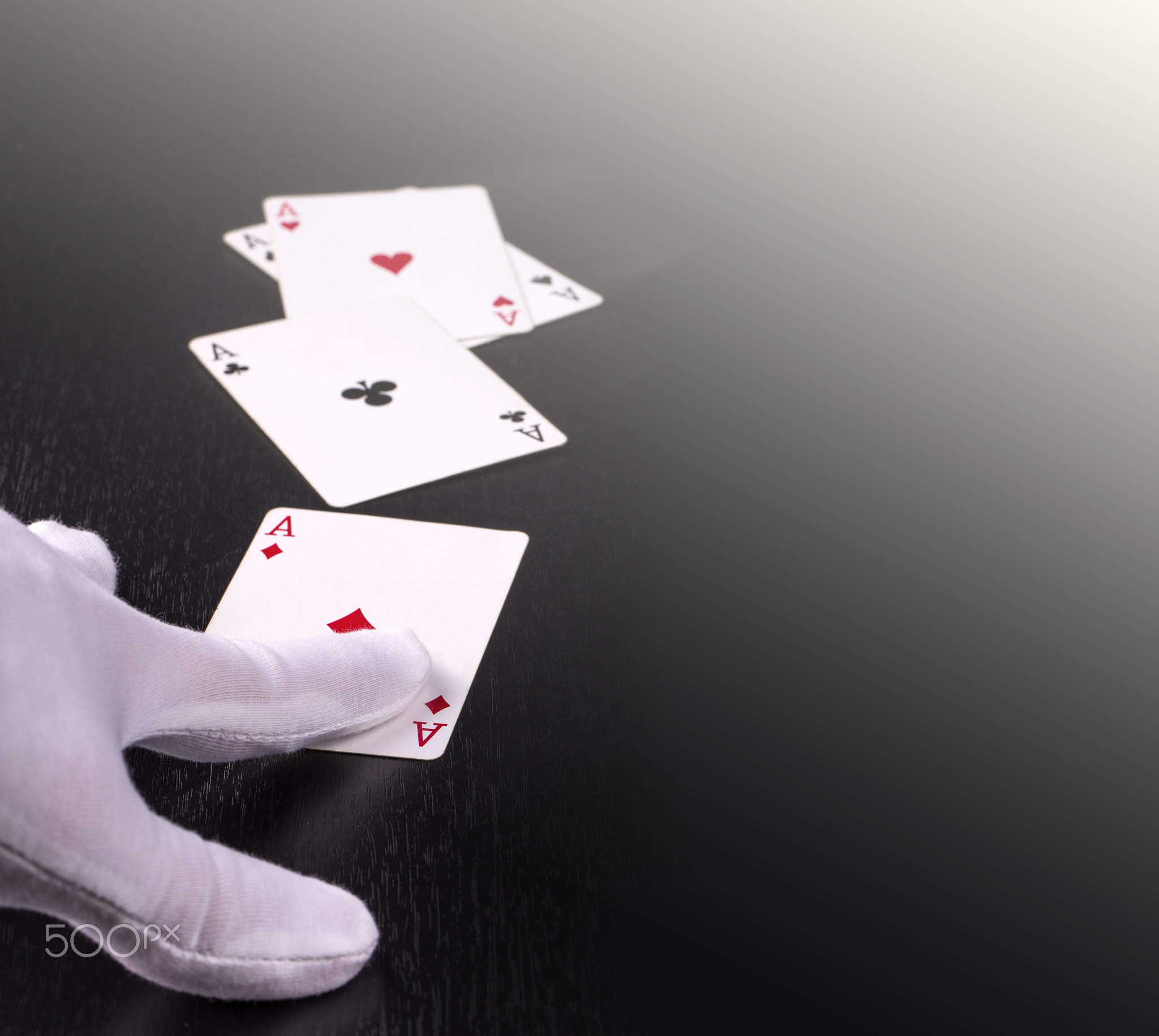 hand of the dealer in white gloves in a casino handing out cards