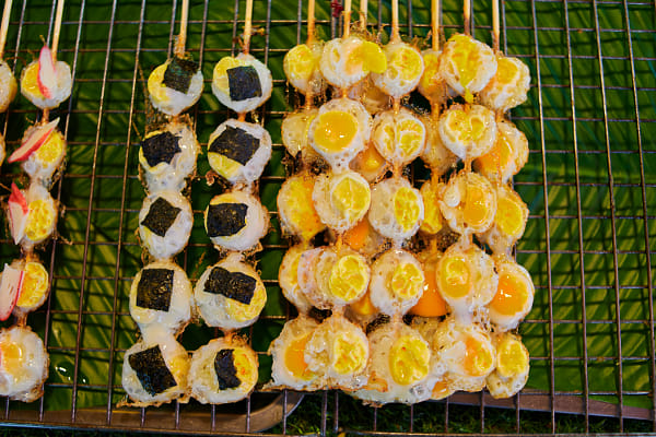 Close-up of grilled skewers quail eggs on barbecue grill at street market by Anucha Muphasa on 500px.com