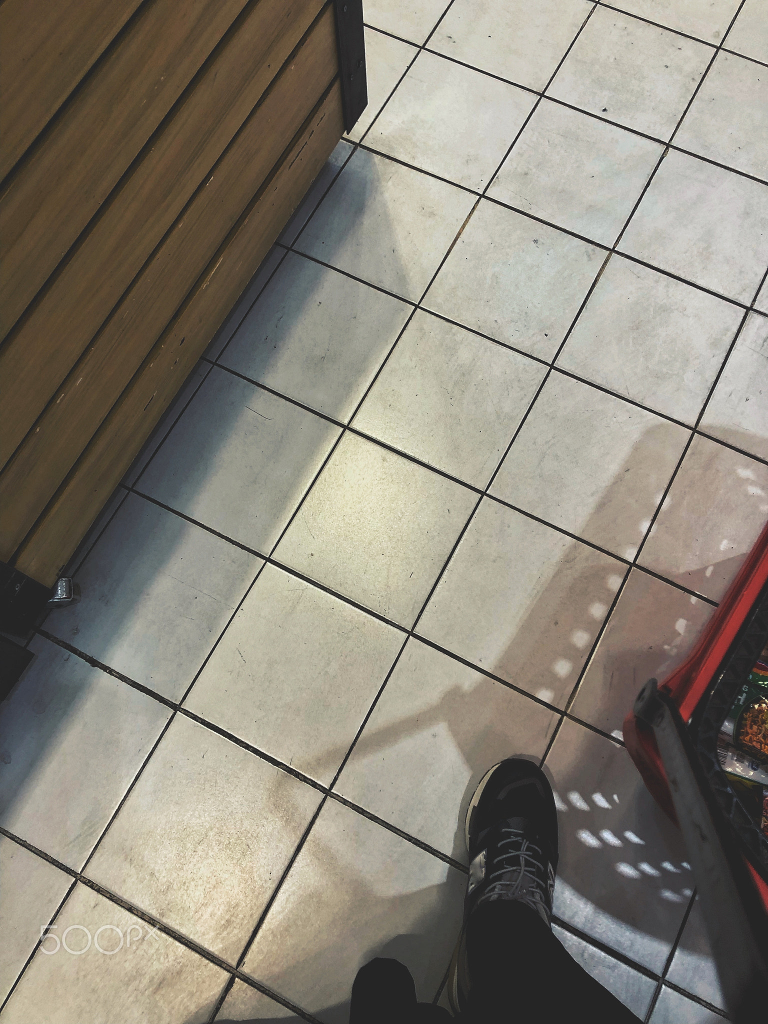 Standing pushing a basket in a supermarket while shopping