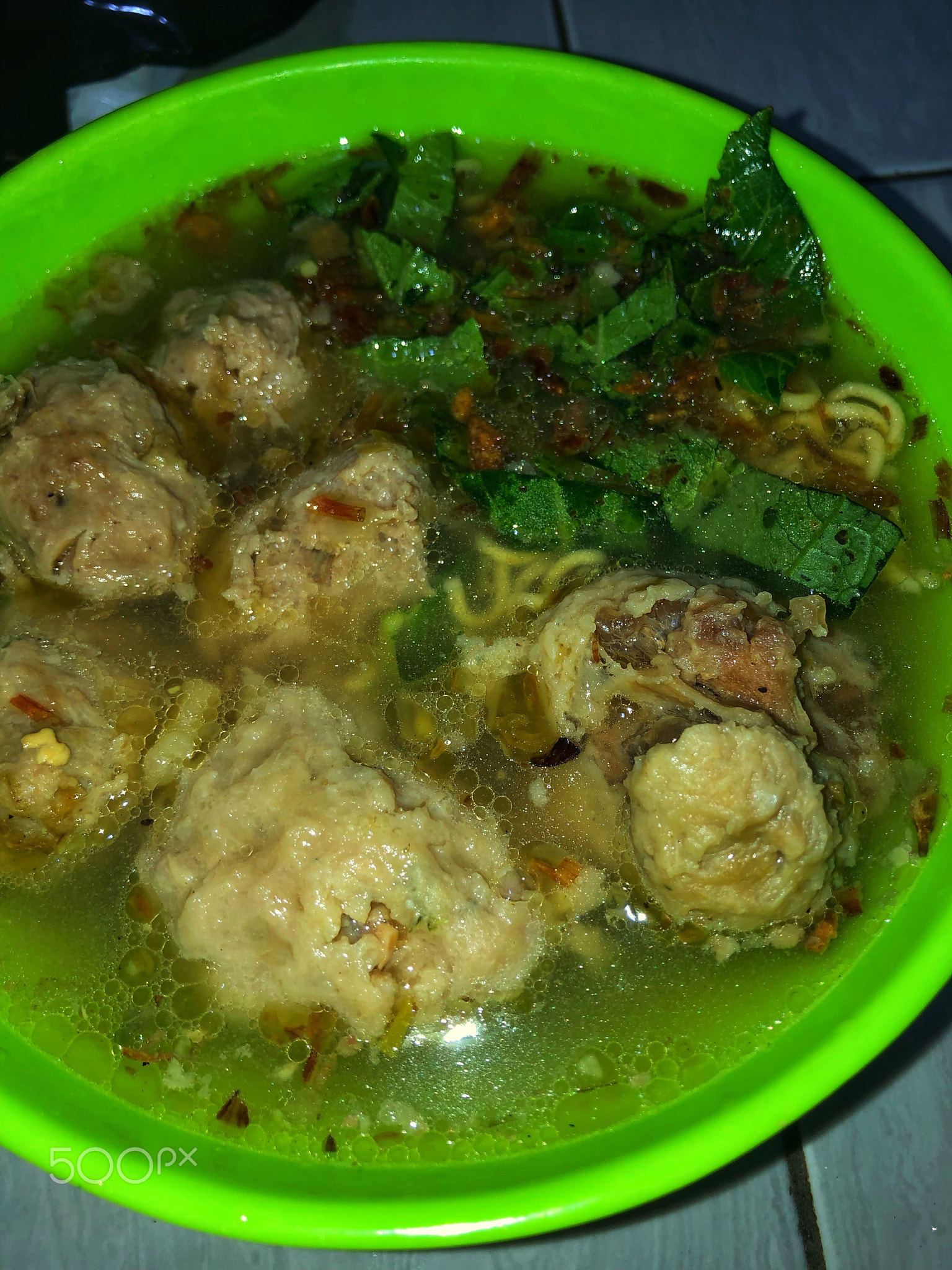 Meatballs with yellow noodles, vegetables and hot sauce are perfect for cold and rainy winters