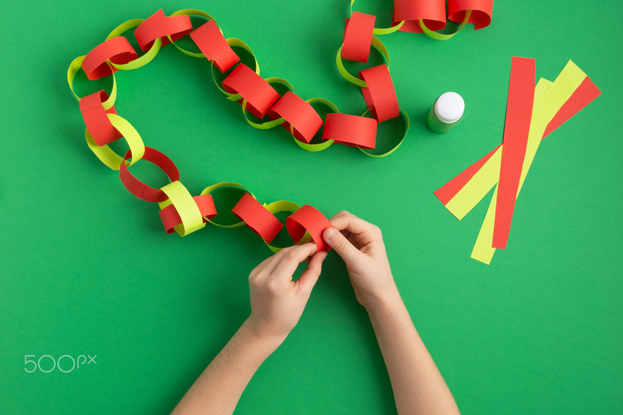 girl hands making paper chain for new year christmas decoration dyi