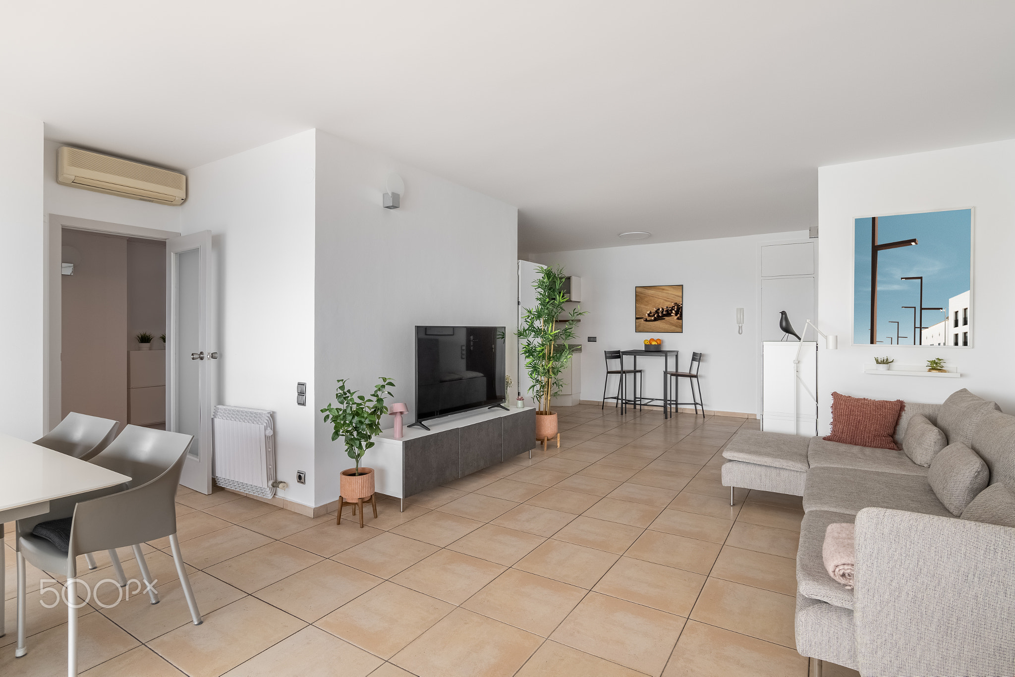 TV set on stand and soft sofa in luxury studio apartment