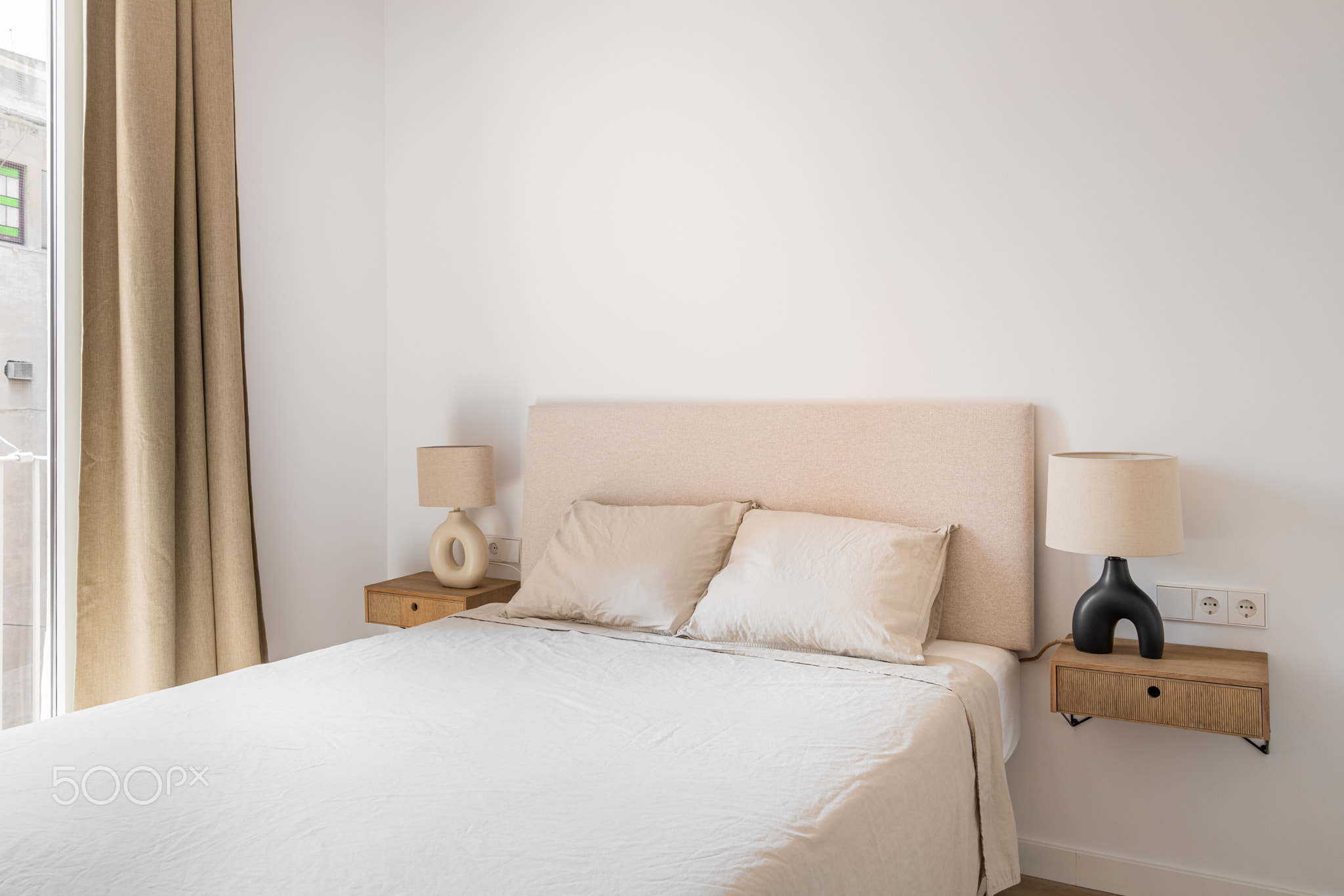 Double bed with pillows and blanket in minimalist bedroom