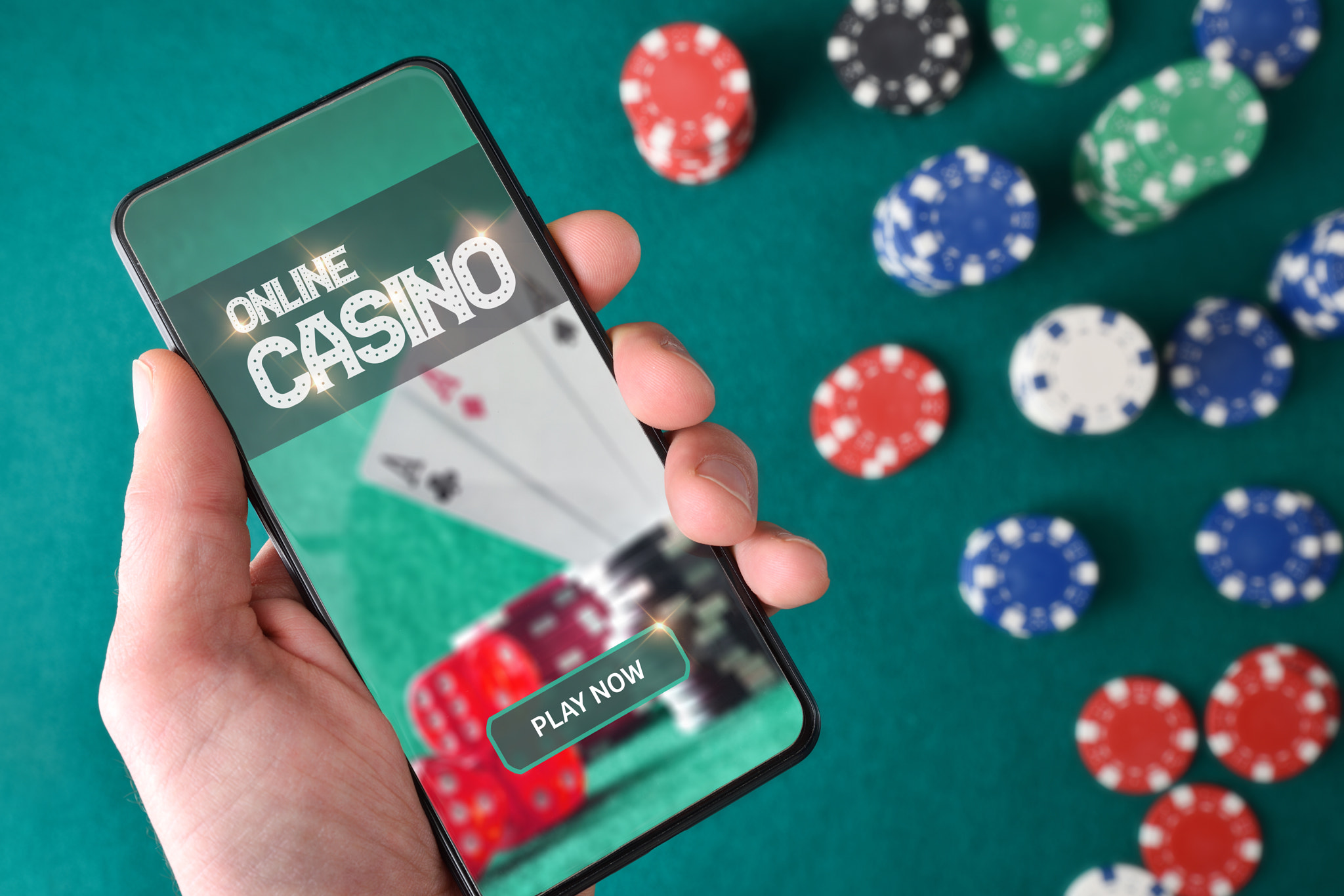 Hand with smartphone showing screen with online casino game