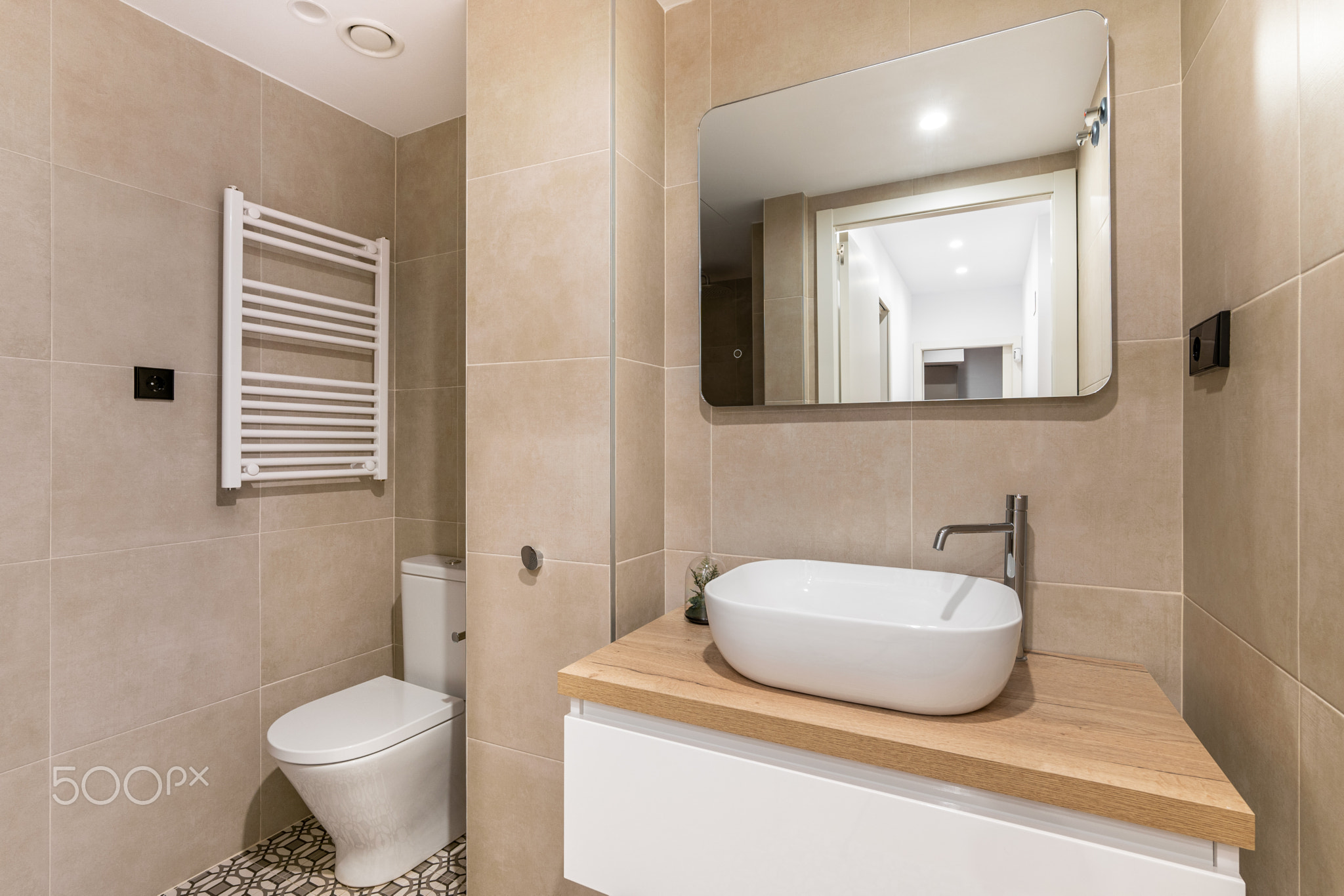 Sink with tap and mirror over chest of drawers in bathroom