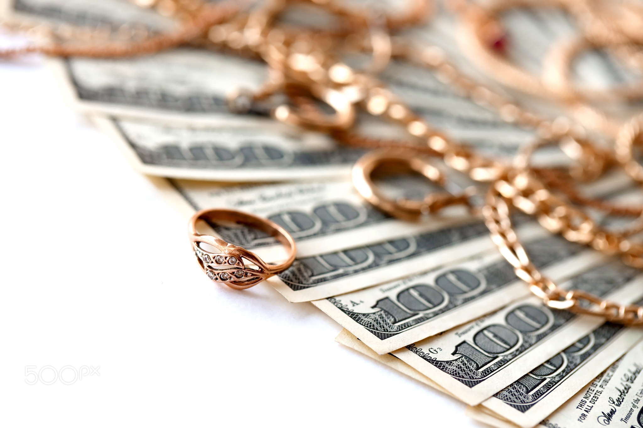 Many expensive golden jewerly rings, earrings and necklaces with big amount of US dollar bills on