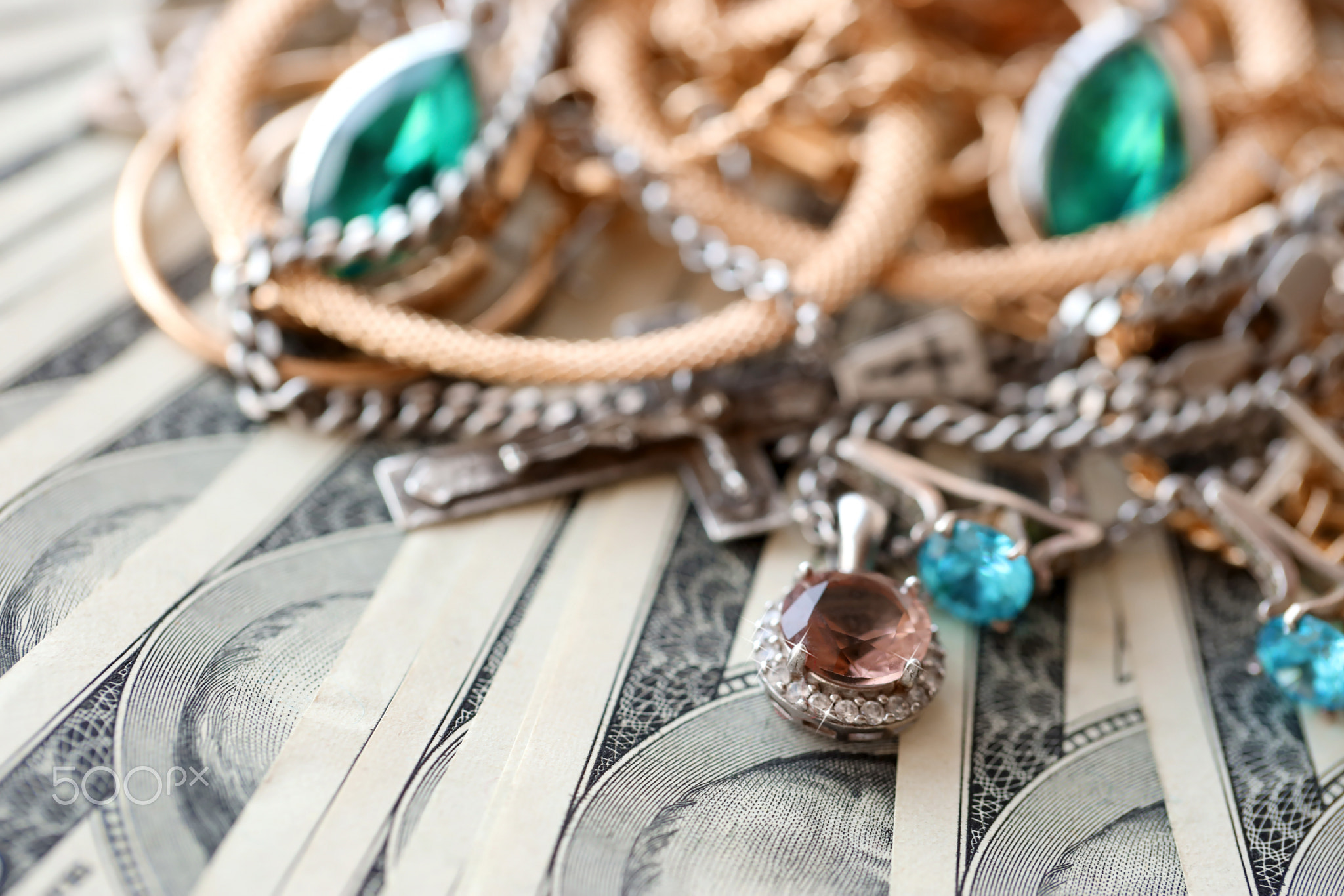 Many expensive golden and silver jewerly rings, earrings and necklaces on big amount of US dollar