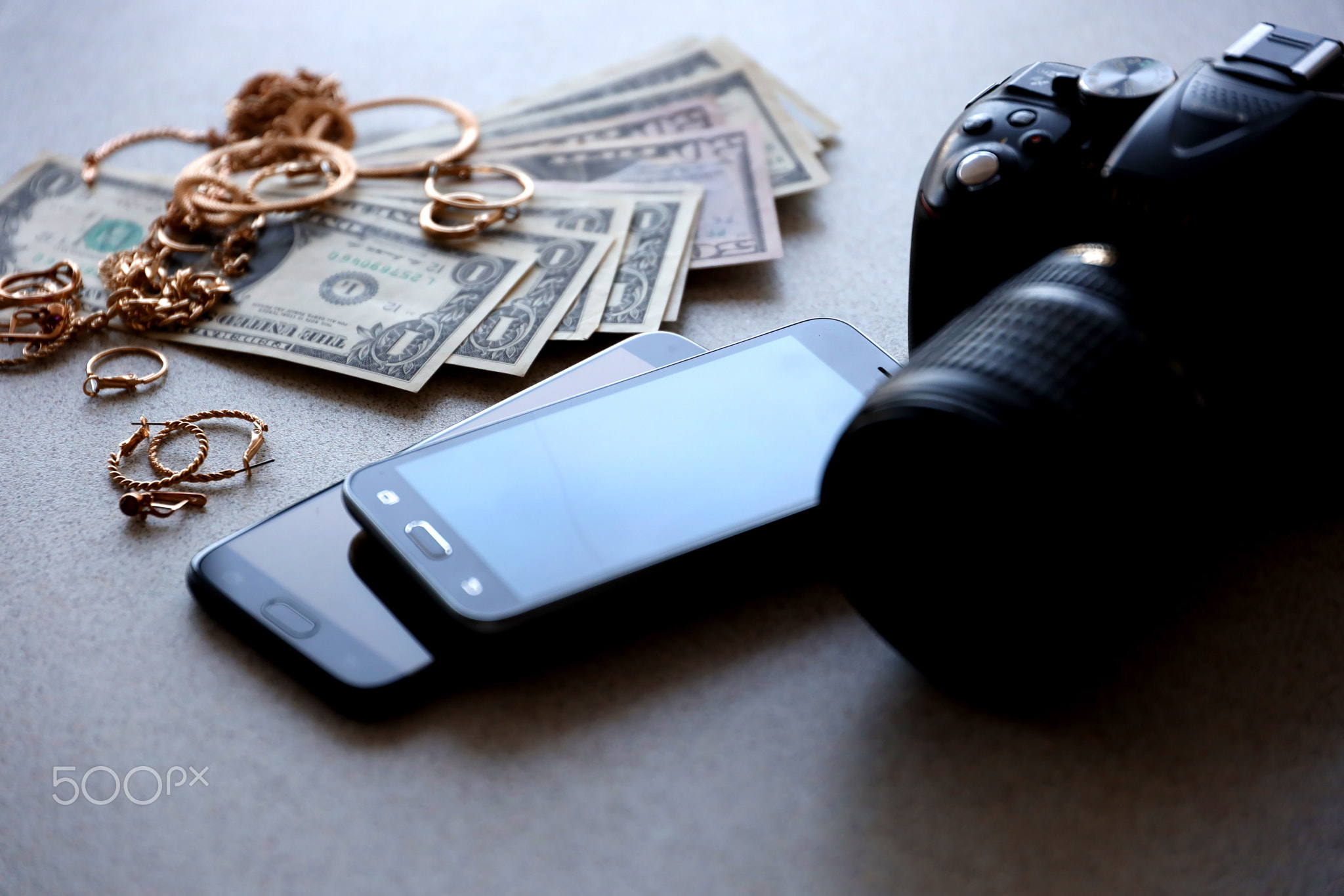 Many expensive golden jewerly rings, earrings and necklaces with big amount of US dollar bills close