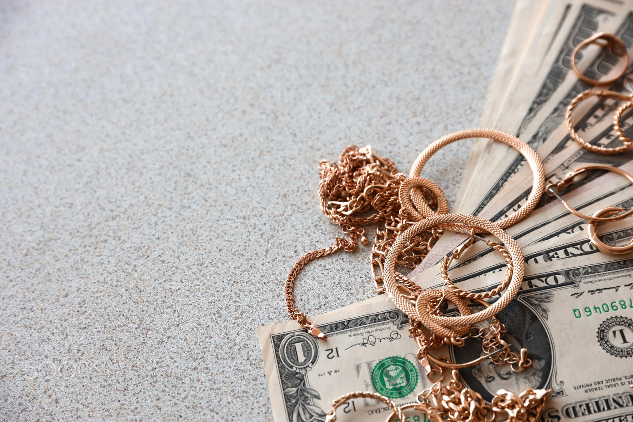 Many expensive golden jewerly rings, earrings and necklaces with big amount of US dollar bills with