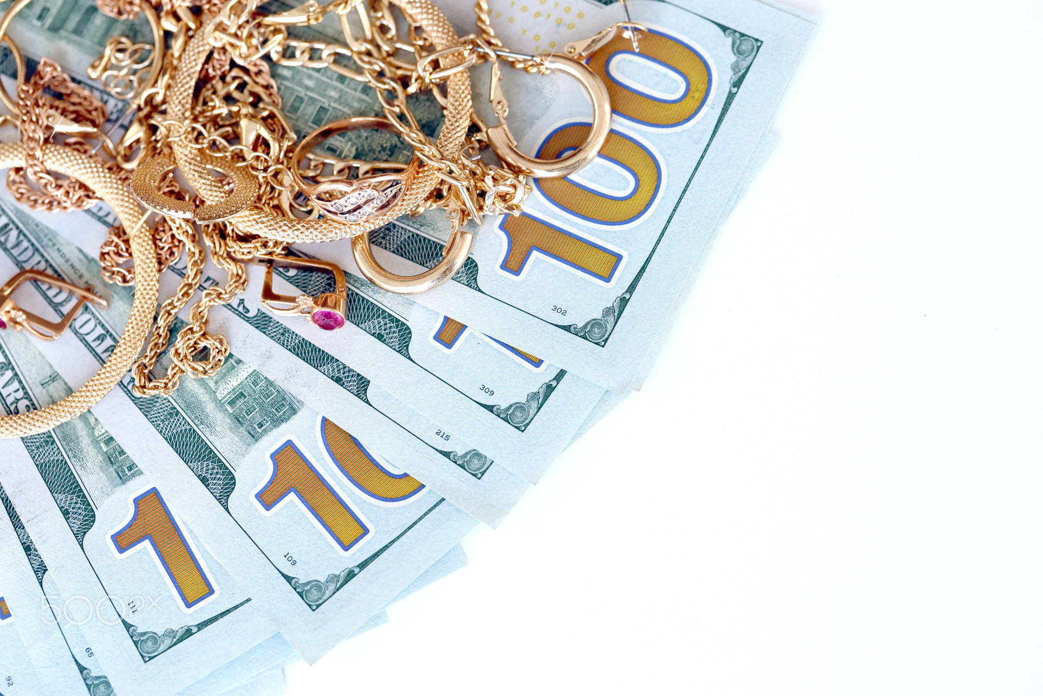 Many expensive golden jewerly rings, earrings and necklaces with big amount of US dollar bills on