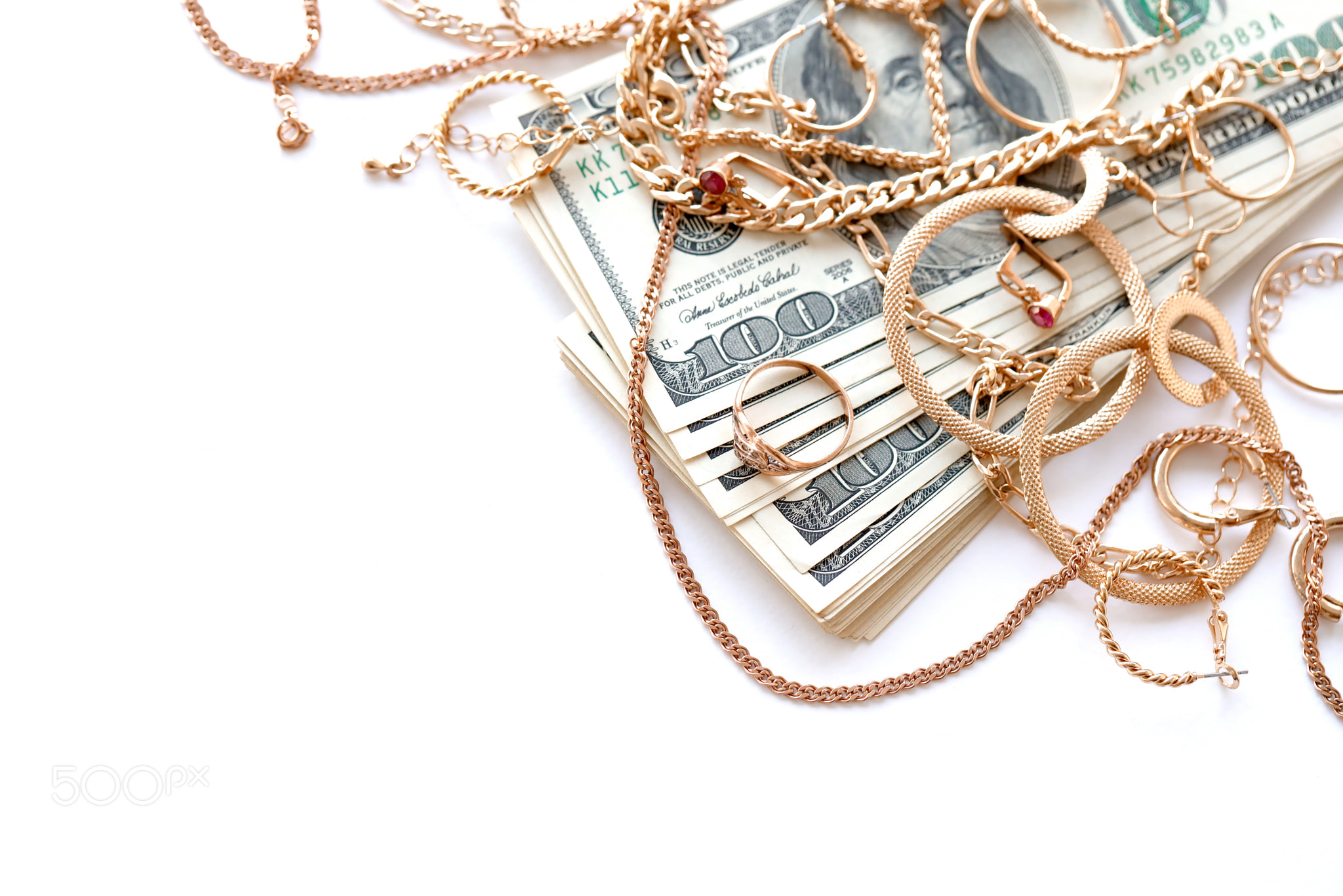 Many expensive golden jewerly rings, earrings and necklaces with big amount of US dollar bills on