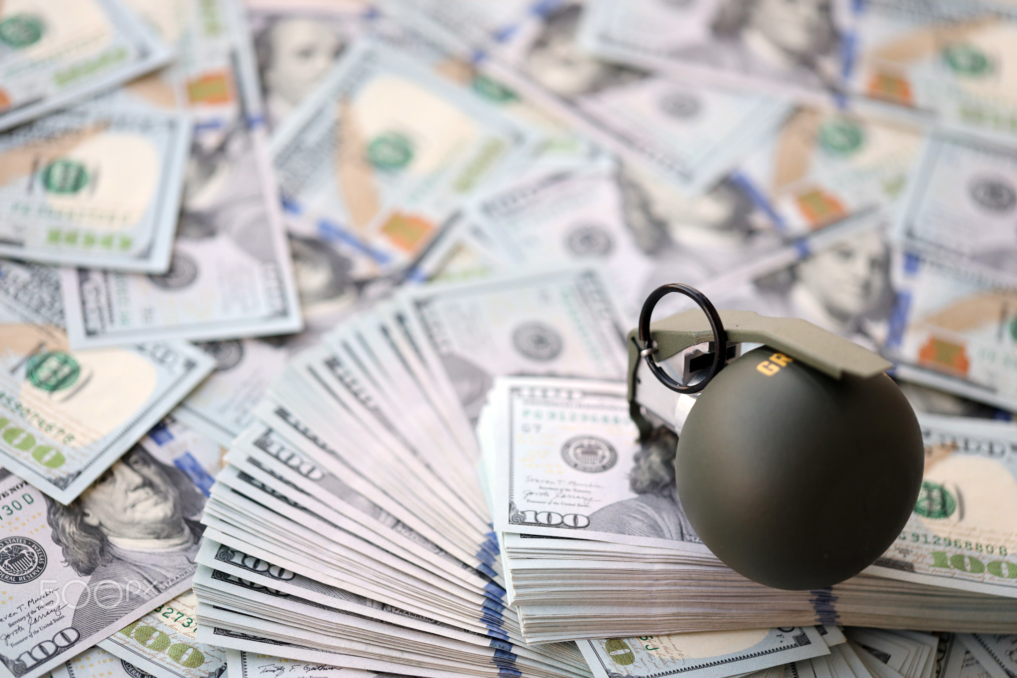 Grenade with a check against the background of huge amount of american dollar bills