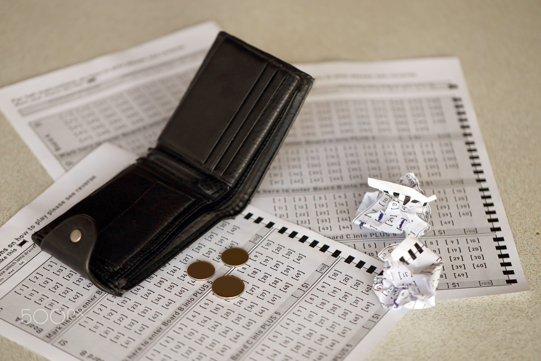Crumpled lottery tickets and empty purse as symbol of losing the lottery game. Unlucky gambling