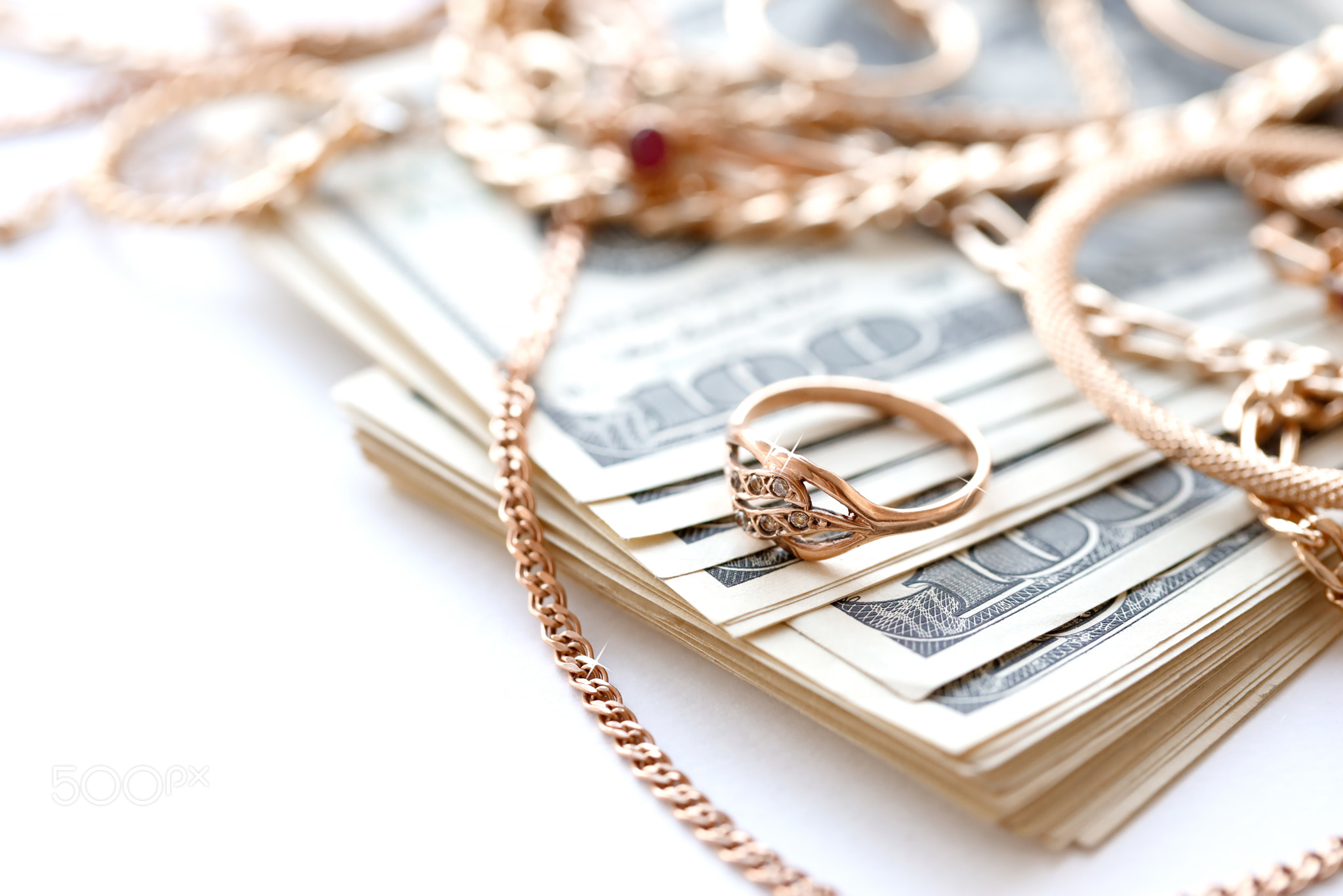 Many expensive golden jewerly rings, earrings and necklaces with big amount of US dollar bills on