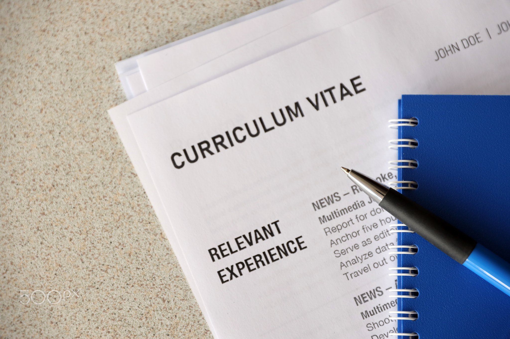 Top view of stack of office documents including resume and cv forms on the desk close to pen and