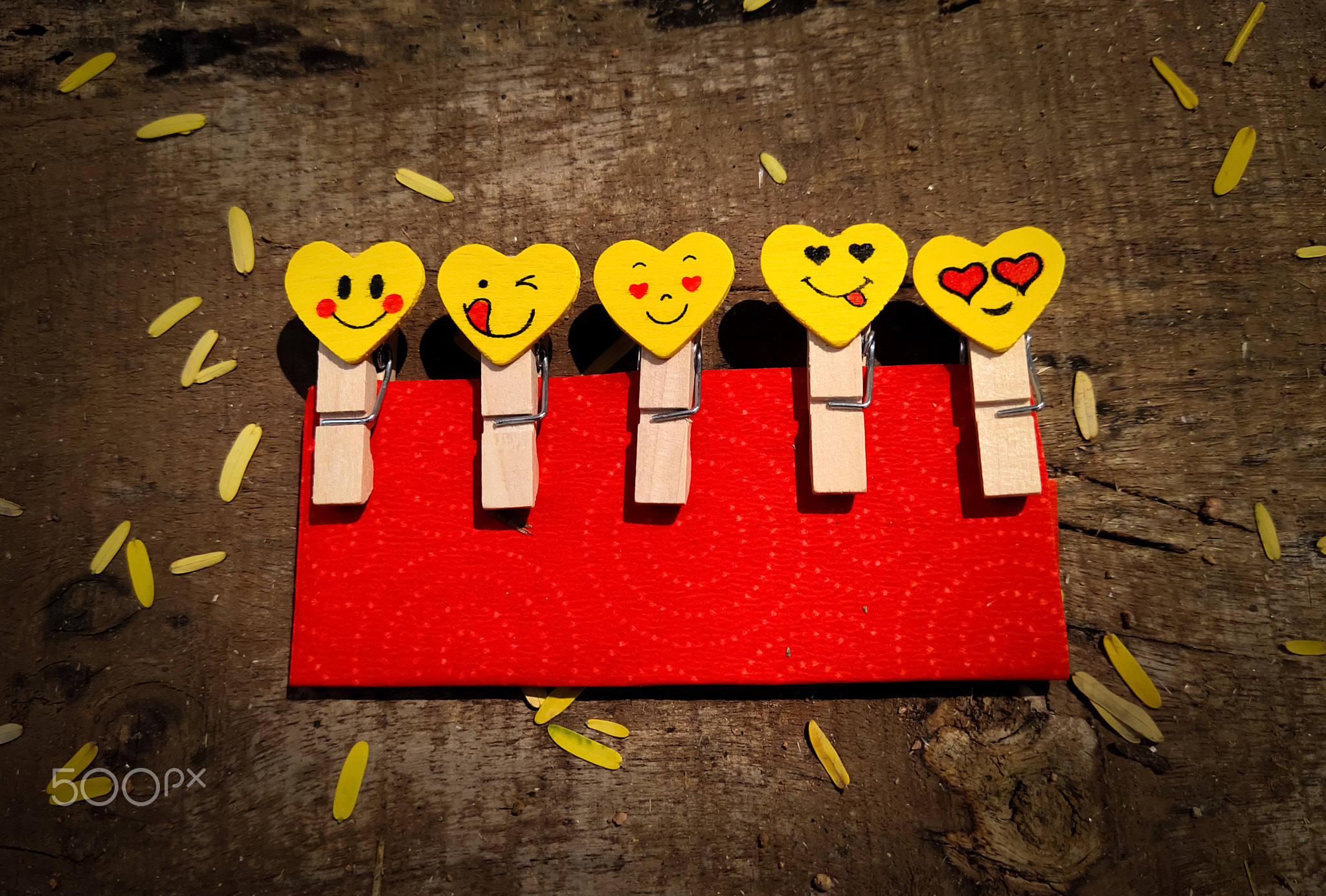 Wooden emoticon paper clips on wood background